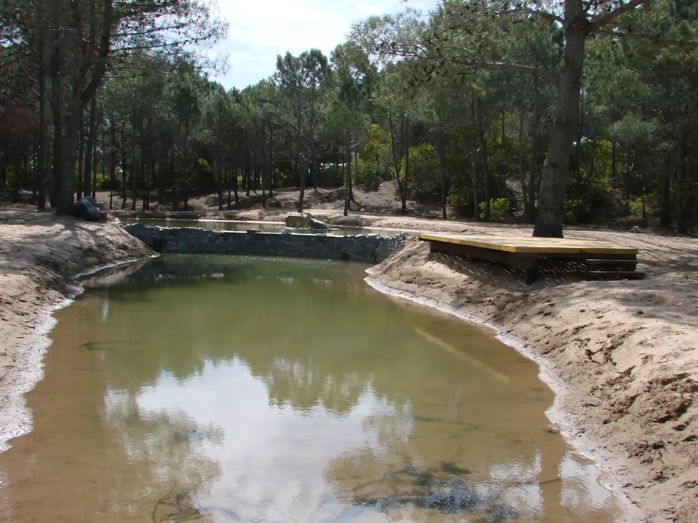 Laguna con barros expuestos y costas en reparación